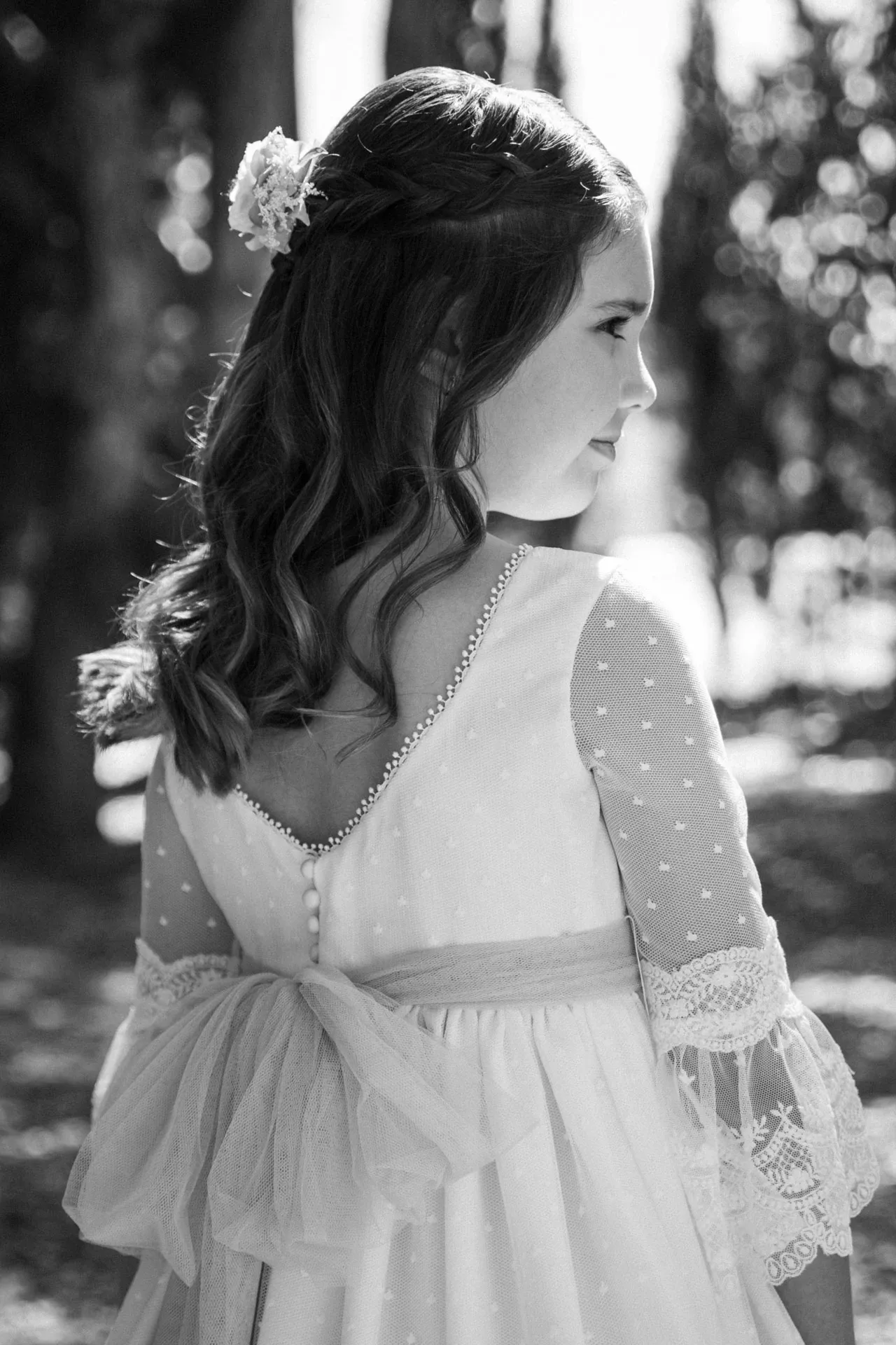 Niña de comunión de espaldas con vestido blanco