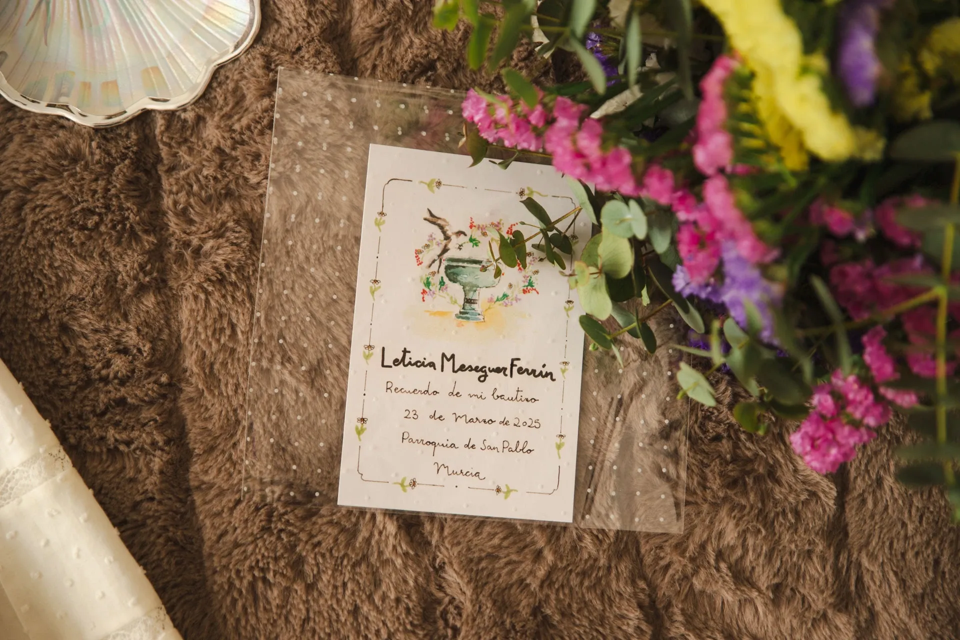 Recordatorio de bautizo rodeado de flores