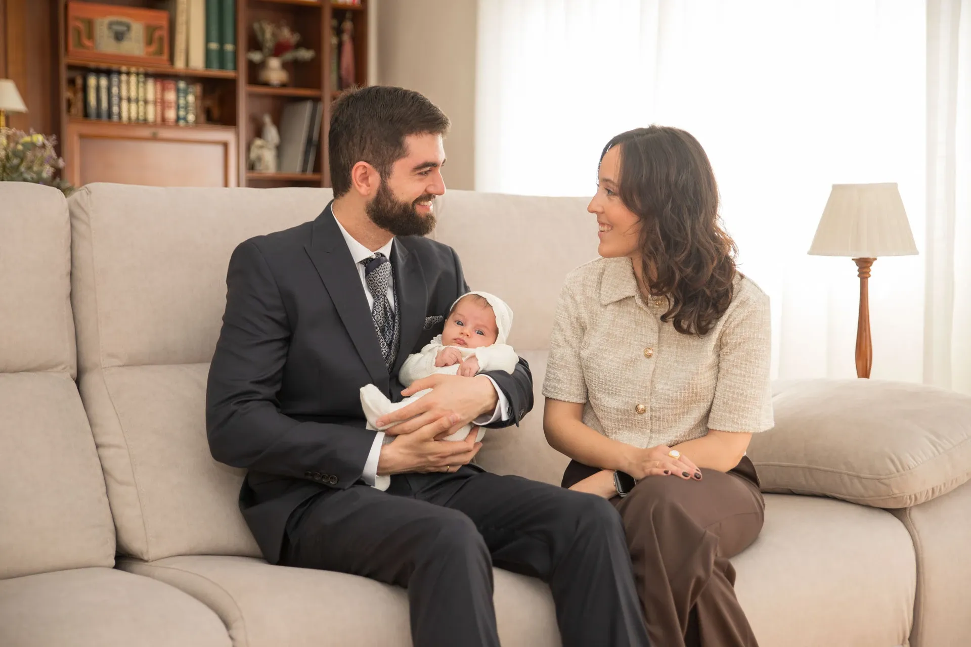 Padres con su bebé en el sofá antes del bautizo