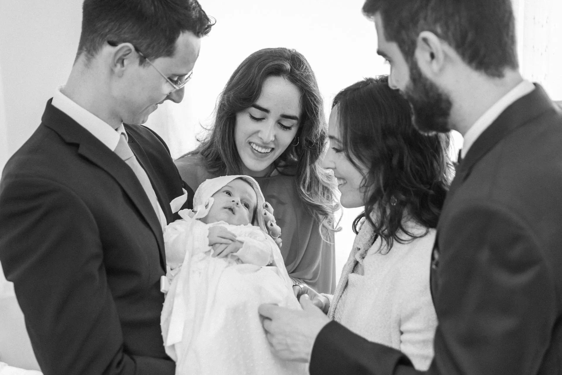 Familia mirando al bebé, en blanco y negro