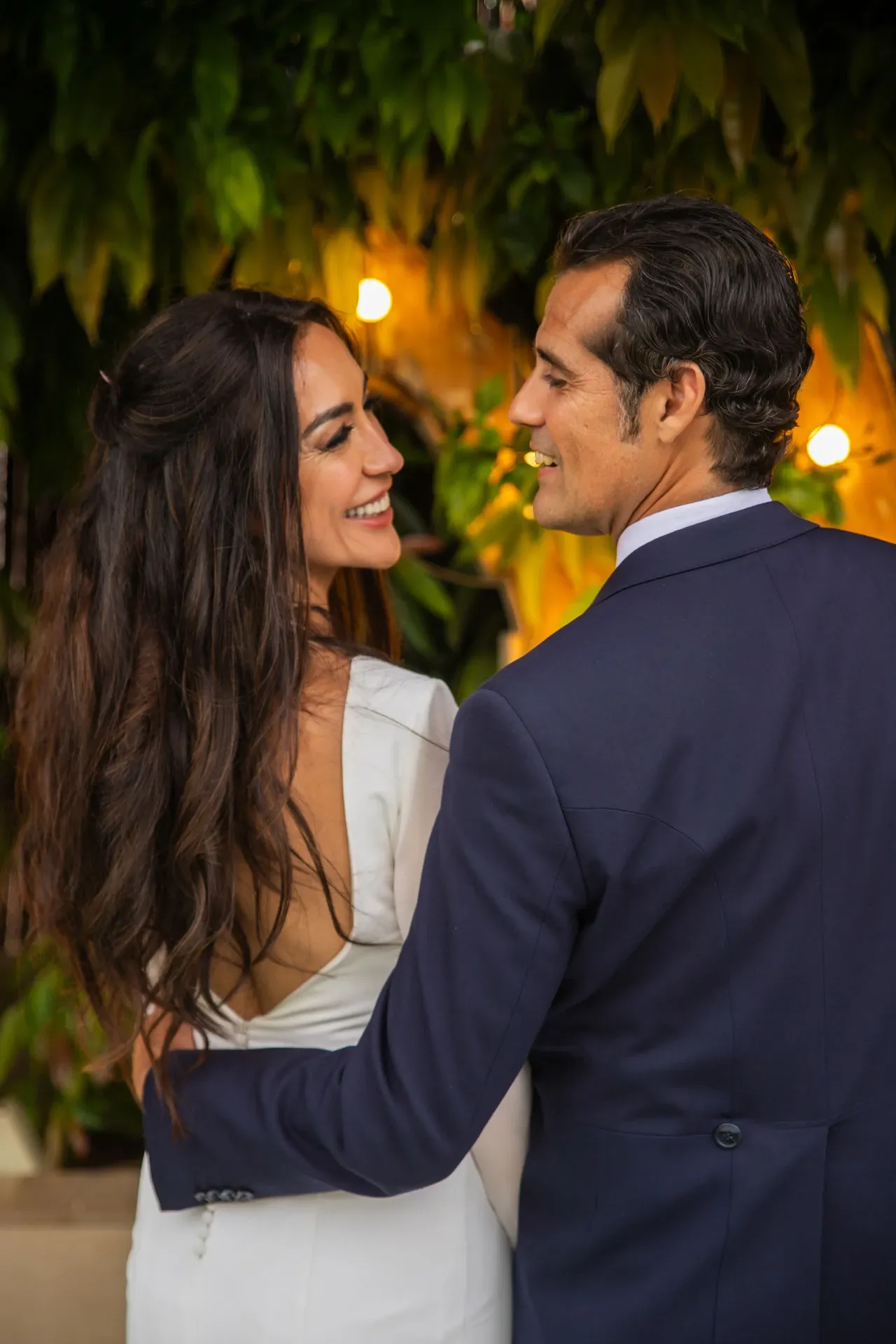 Novios mirándose en un jardín de noche
