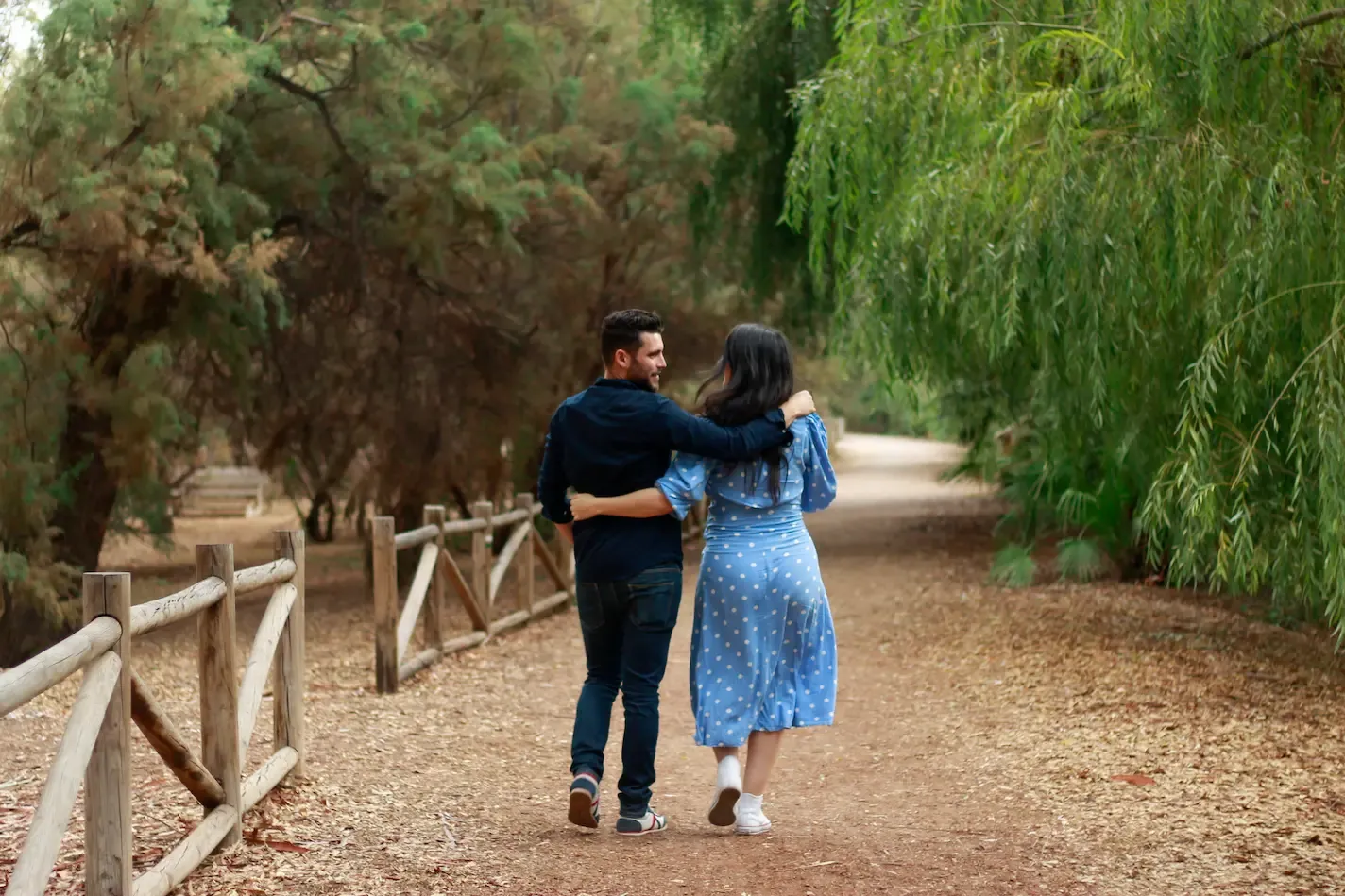 Pareja paseando por un camino en una sesión de embarazo