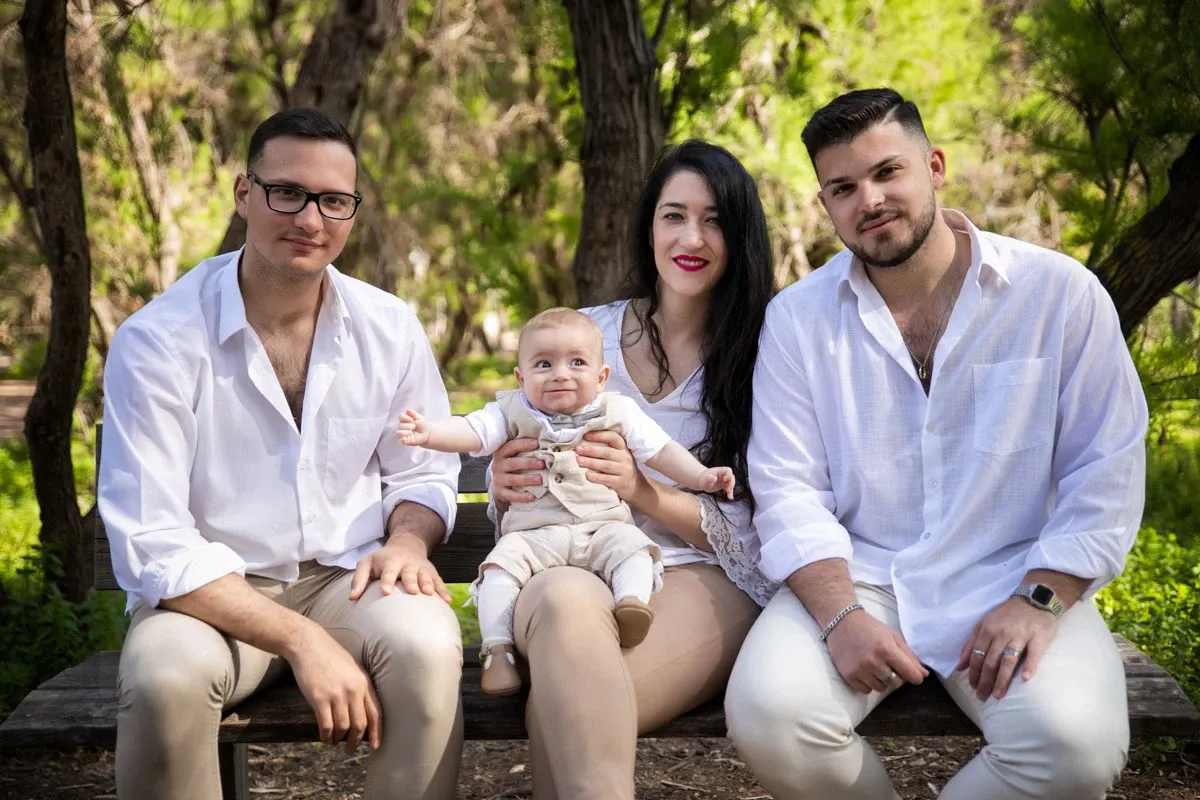 Padres y familiares con el bebé en un banco del parque