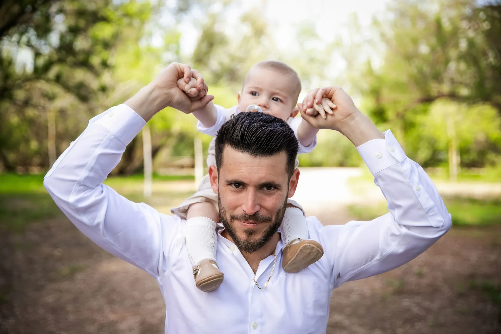 Padre con su bebé a hombros en el parque