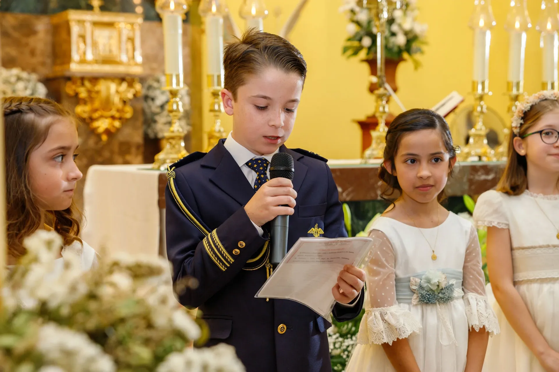 Niño de comunión leyendo en el altar