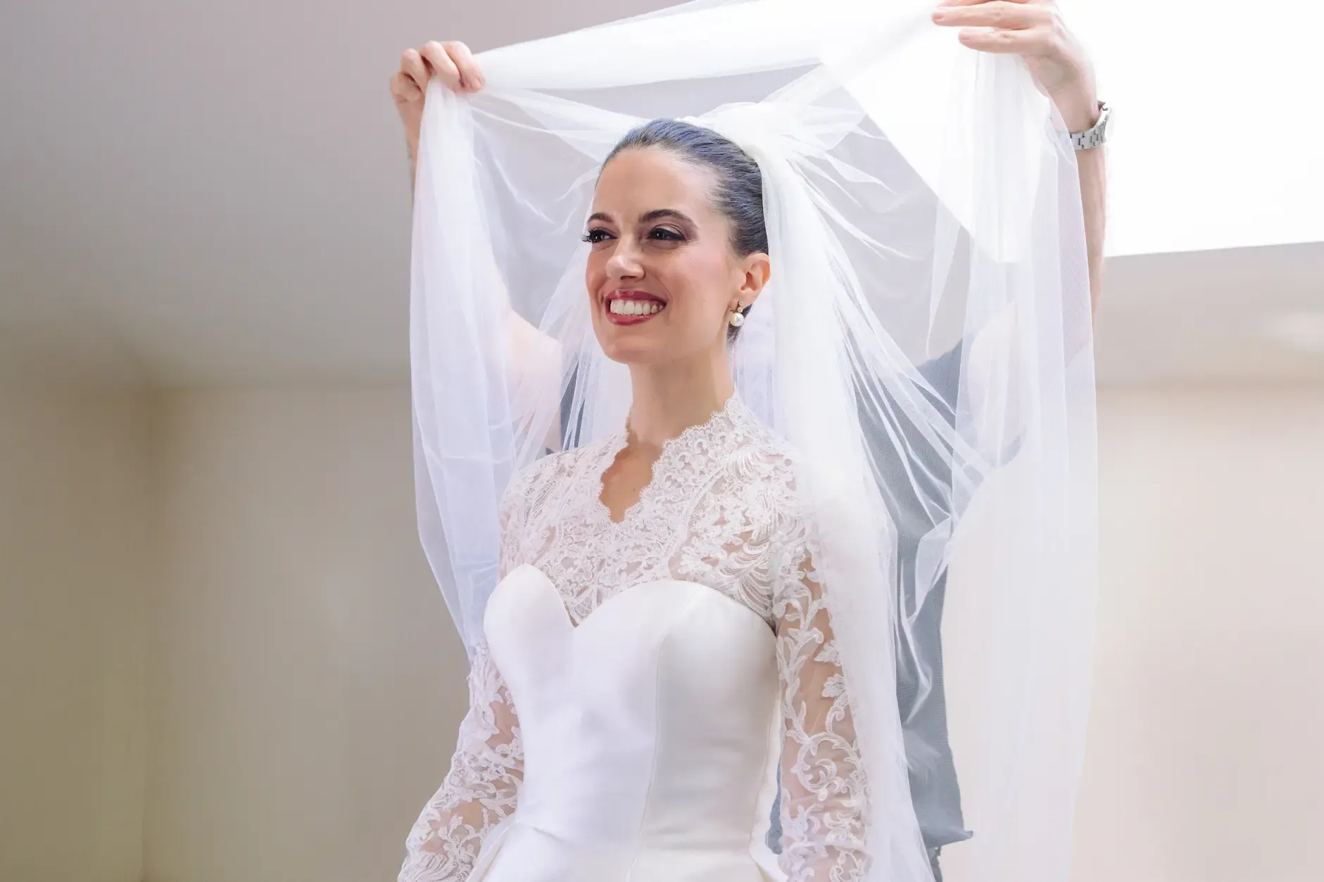 Novia sonriente colocándose el velo