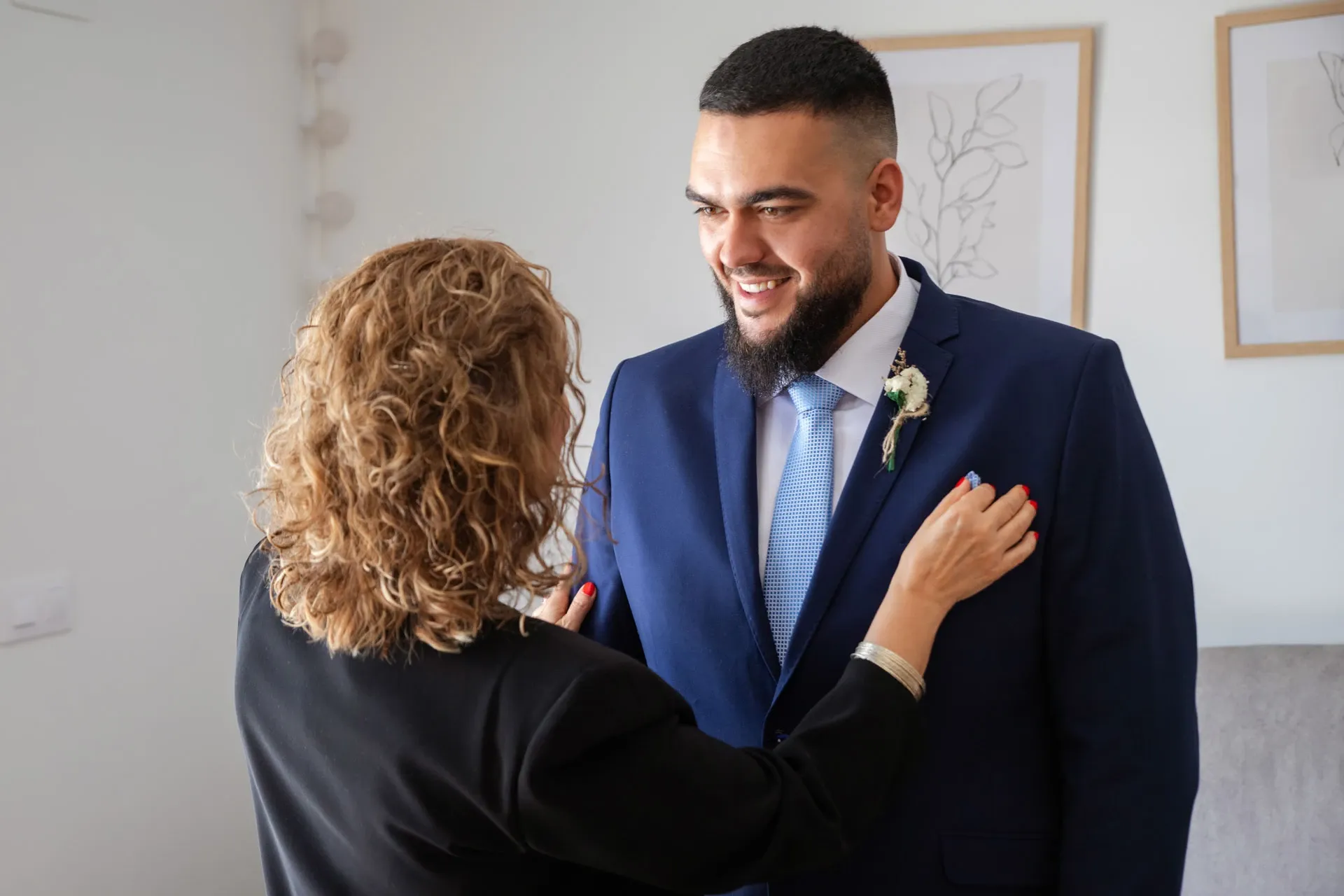 Madre colocando el traje al novio