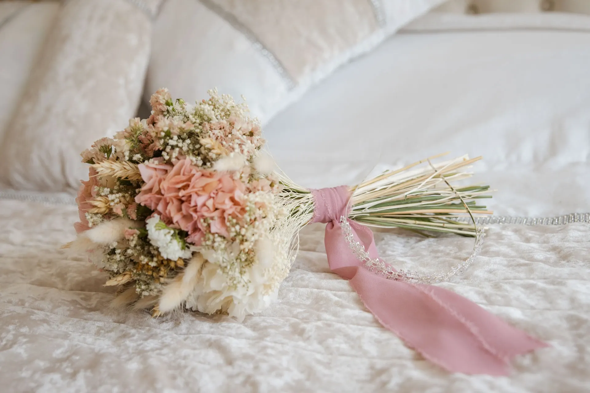 Ramo de flores secas sobre la cama de la novia