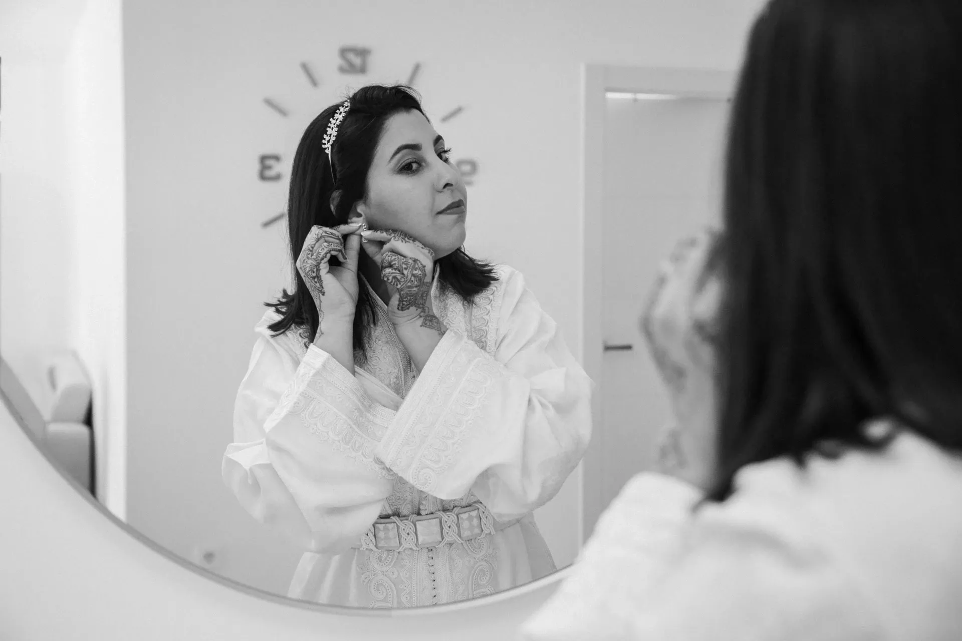 Novia arreglándose frente al espejo, en blanco y negro