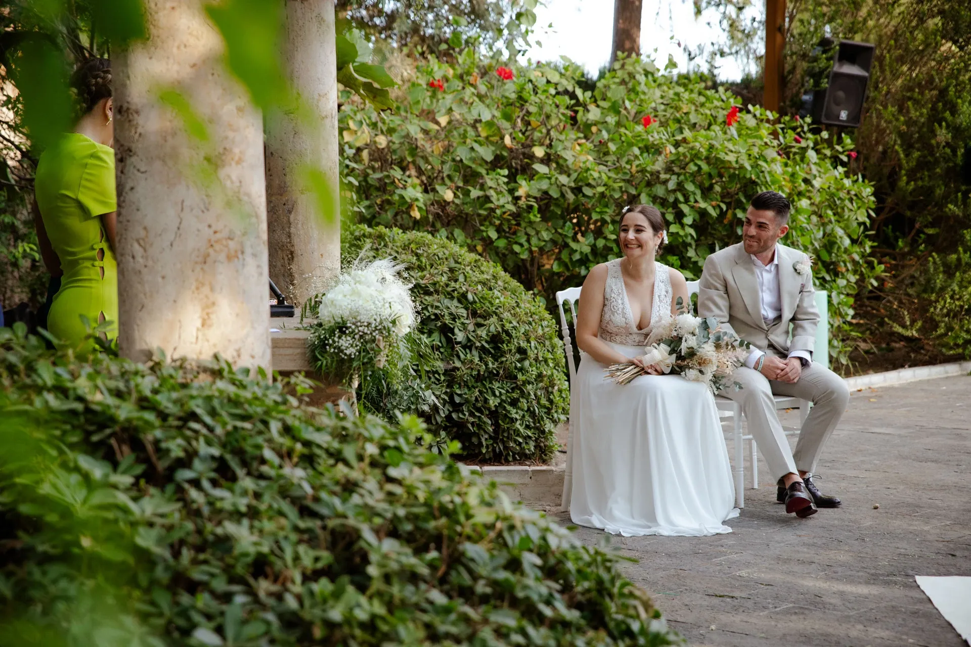 Novios sentados en una ceremonia civil en un jardín