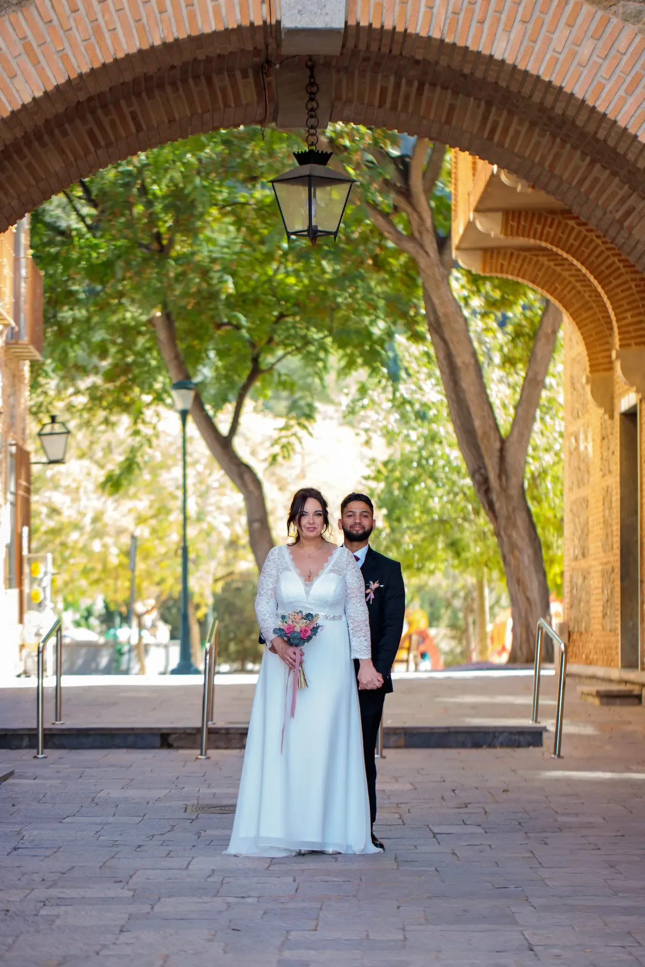 Novios bajo un arco de piedra