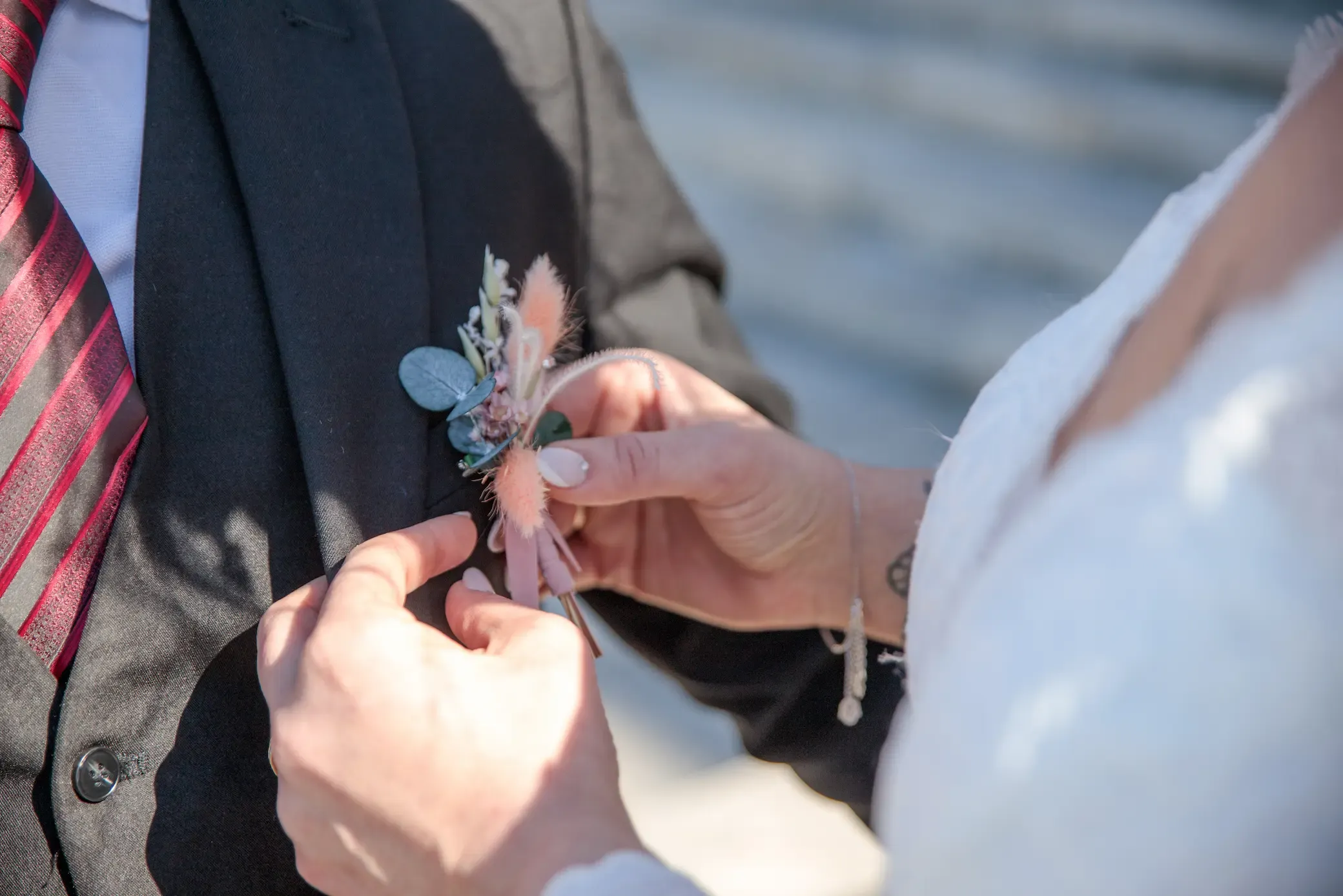 Novia colocando la flor en la solapa del novio