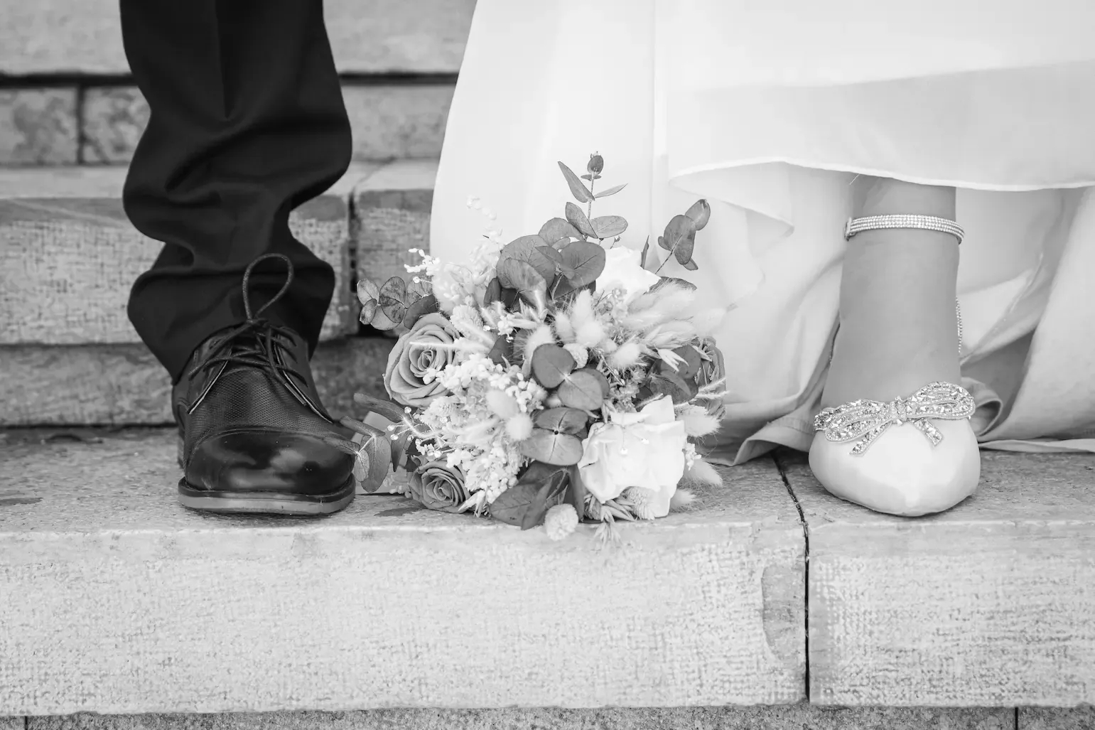 Zapatos de los novios y ramo de flores, en blanco y negro