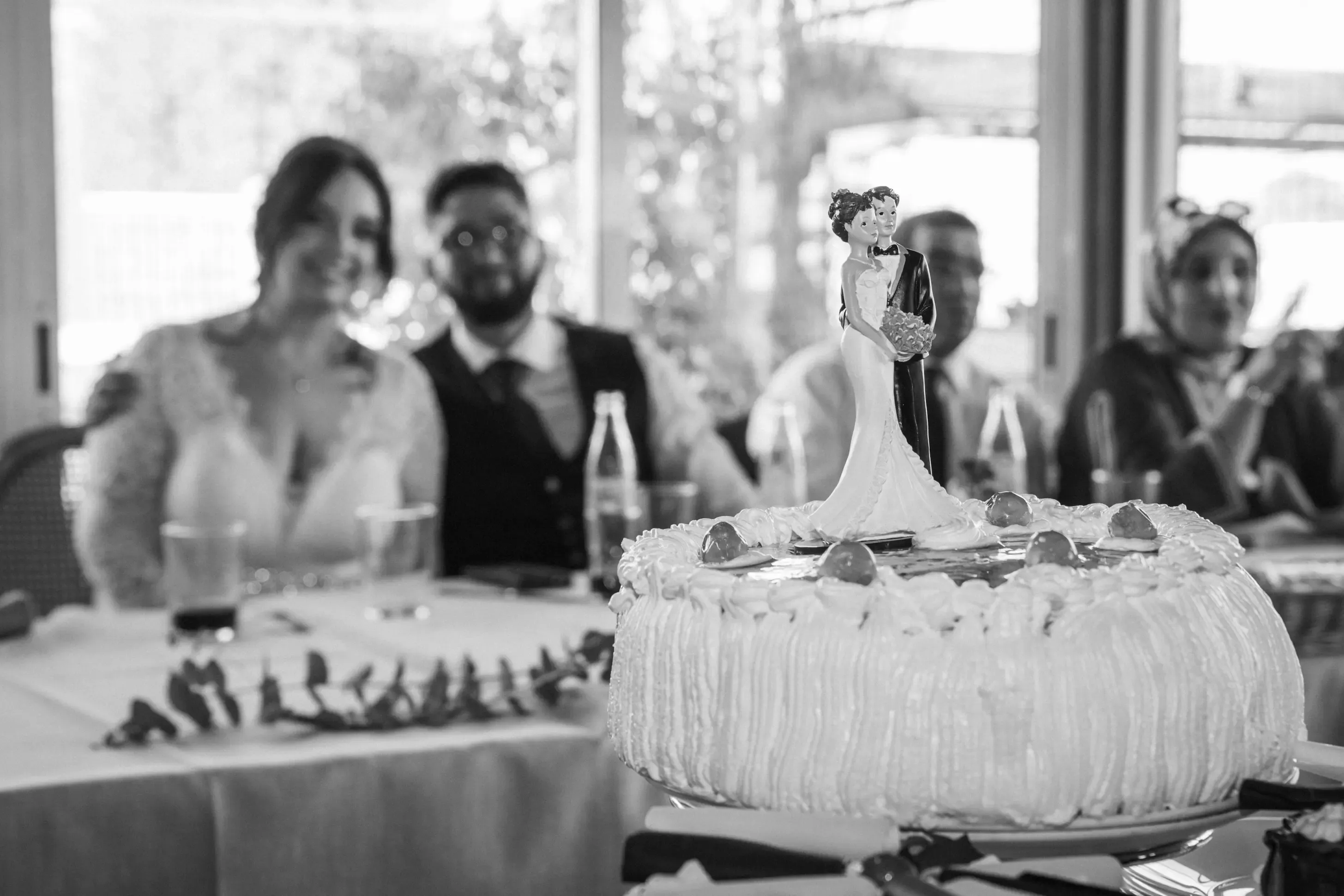 Invitados junto a la tarta nupcial en el banquete