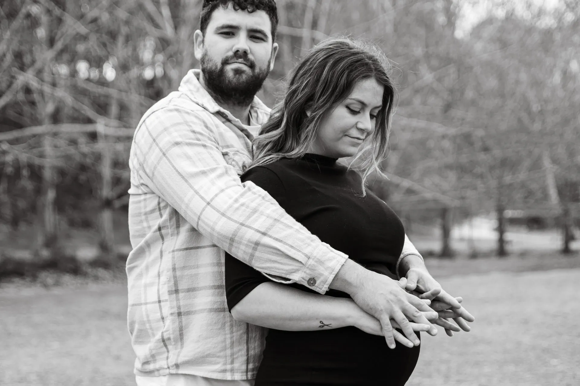 Pareja con las manos sobre la tripa de embarazo, en blanco y negro