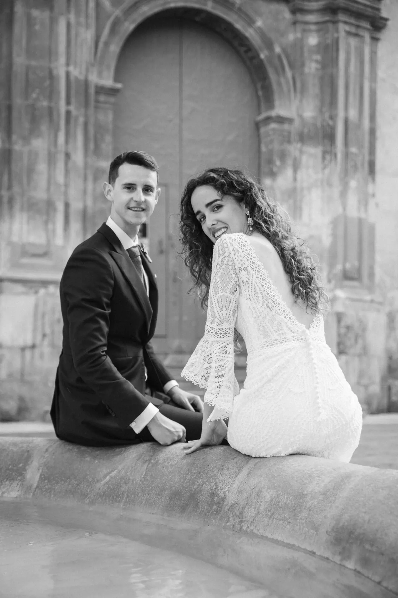 Novios sentados en una fuente, en blanco y negro