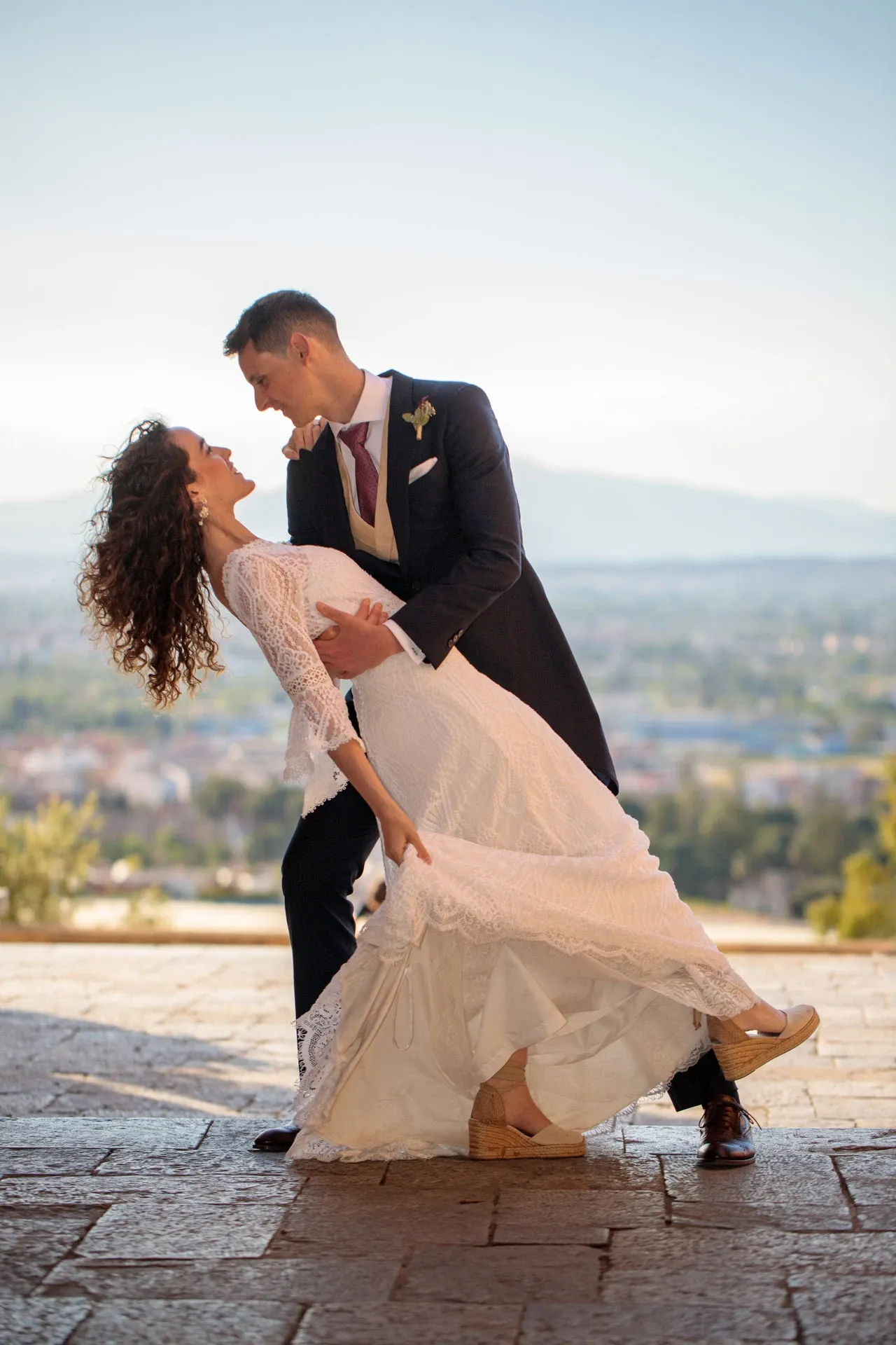 Novio inclinando a la novia en una postboda con vistas