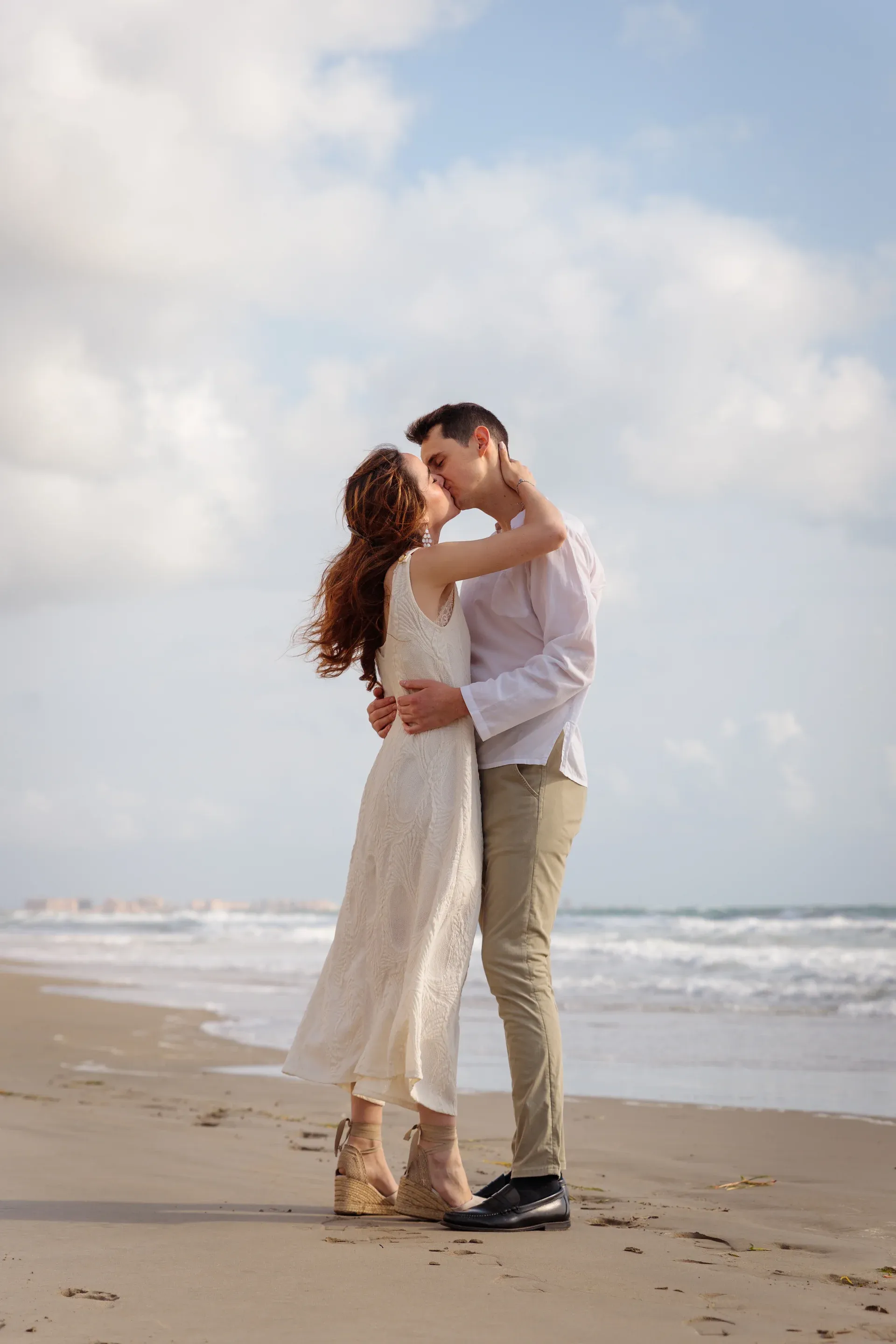 Pareja besándose en la orilla durante su preboda en la playa