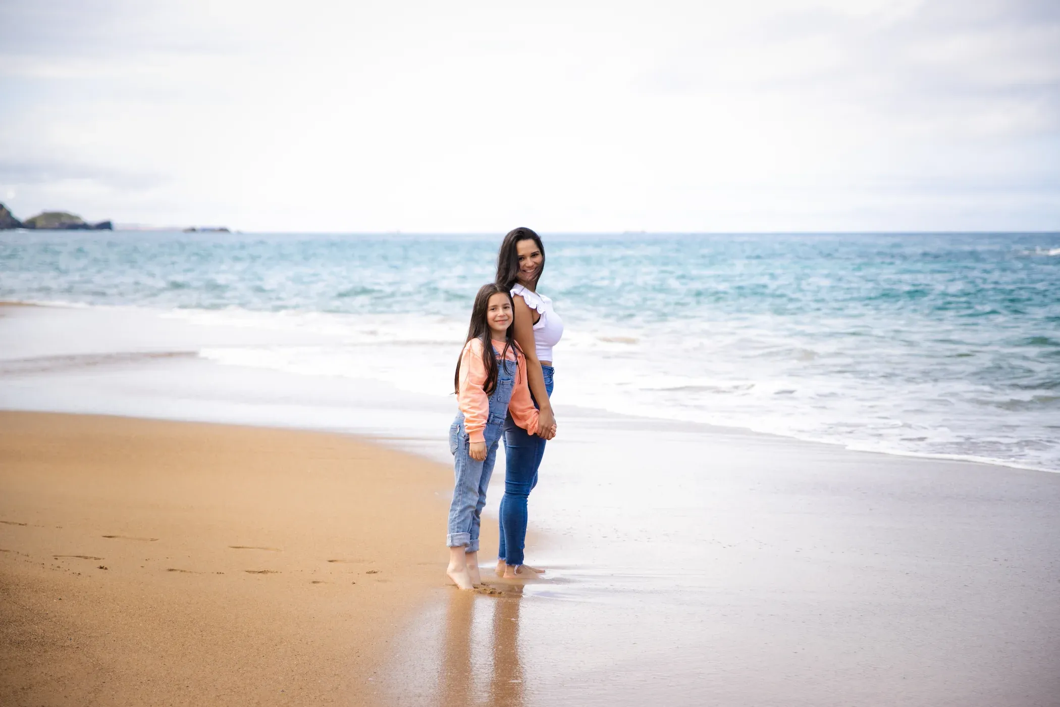 Madre e hija en la orilla del mar