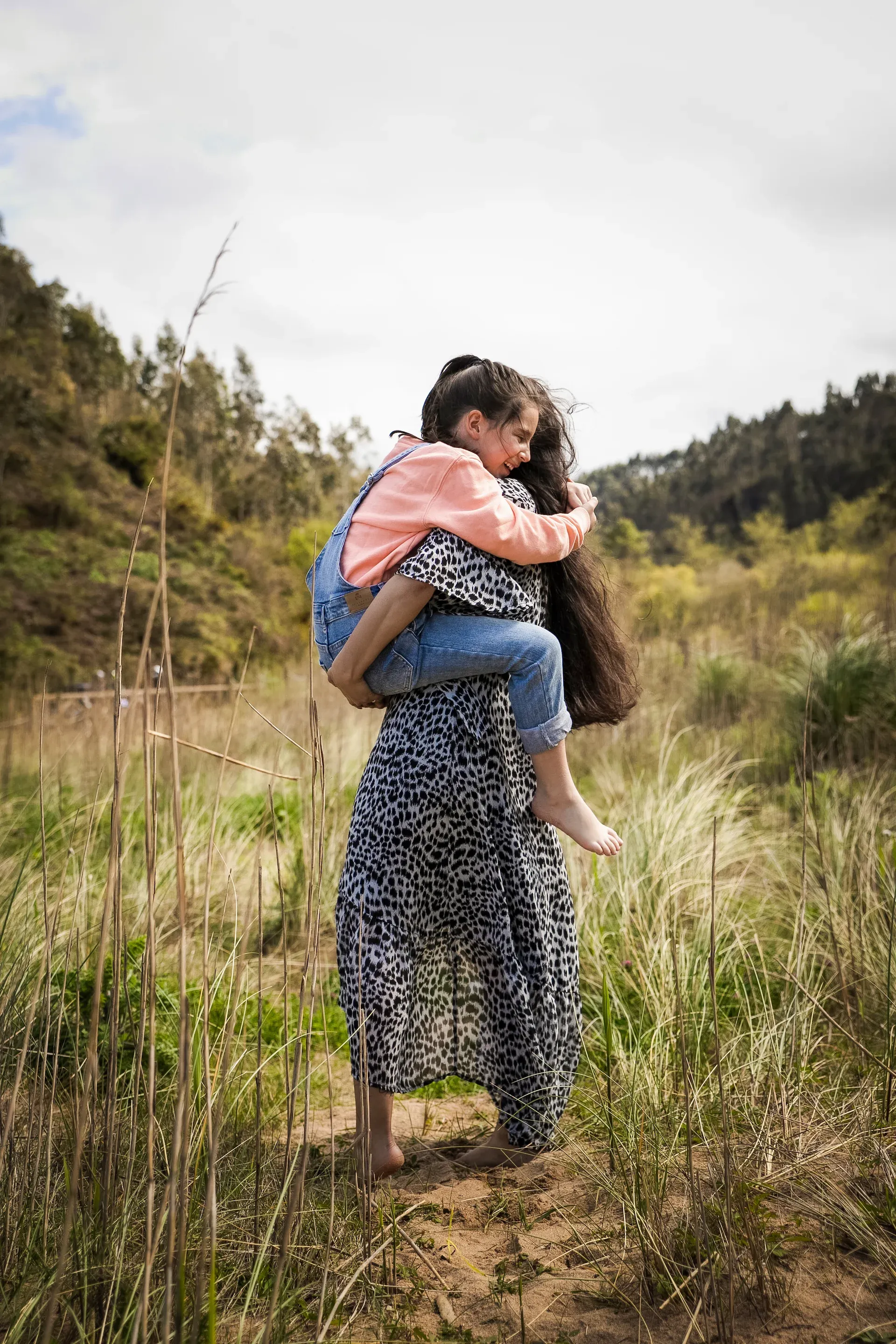 Hija abrazada a su madre en el campo
