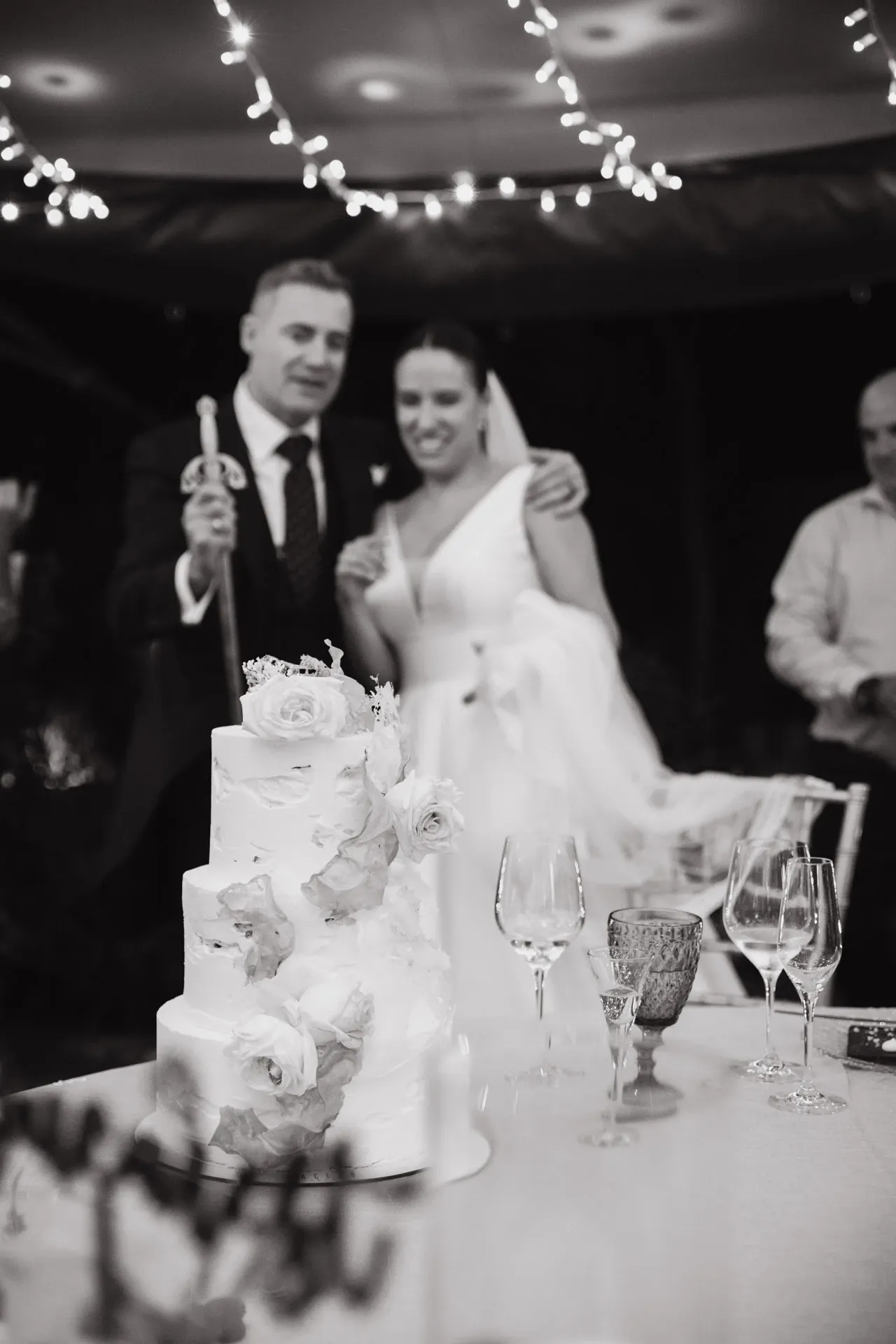 Novios junto a la tarta nupcial, en blanco y negro