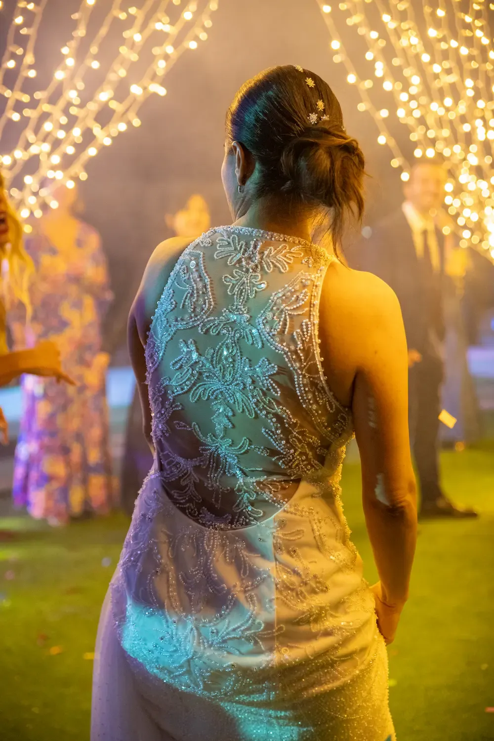 Invitada de espaldas bajo las luces del banquete