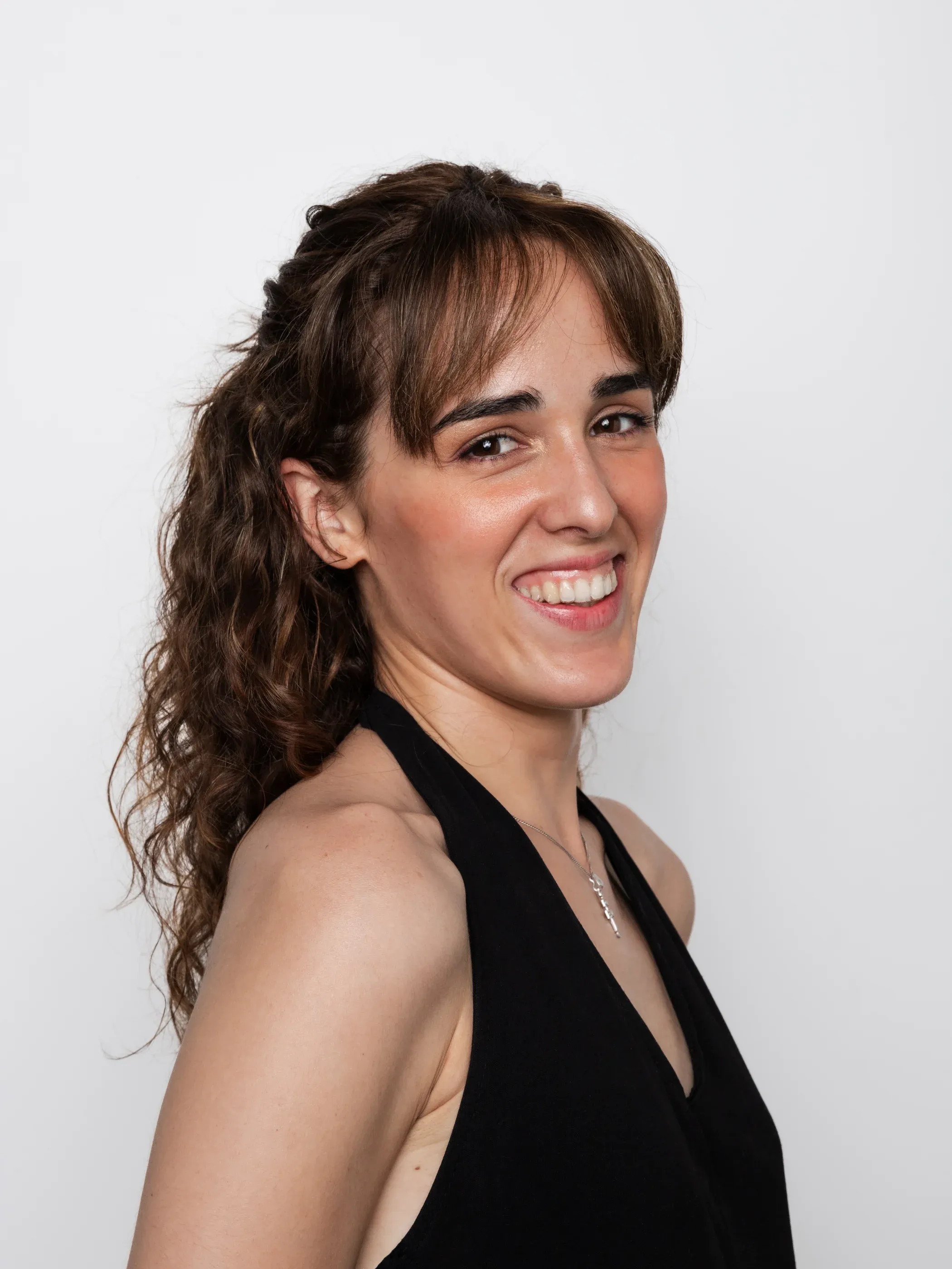 Retrato profesional de una mujer sonriente sobre fondo gris