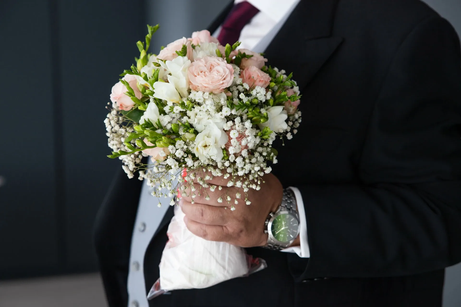 Padrino sujetando el ramo de la novia