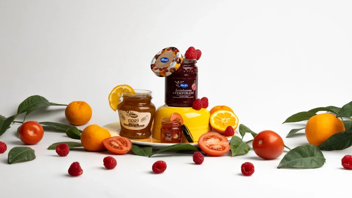 Mermeladas y frutas frescas sobre fondo blanco