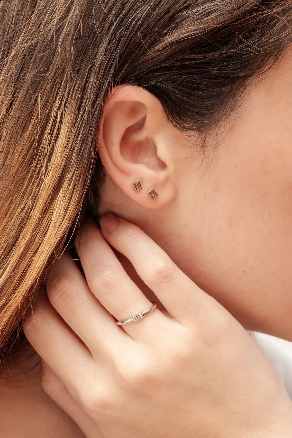 Modelo luciendo pendientes y anillo, fotografía de joyería